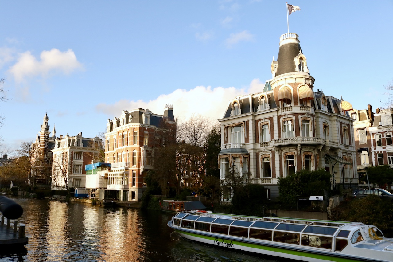 Boat floating on a canal in Amsterdam on a clear blue day